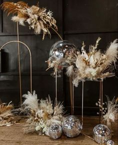 some silver balls and feathers are sitting on the floor