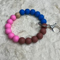 a pink, blue and brown beaded bracelet with a pair of scissors on it