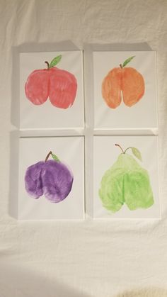 four different colored apples and pears on white paper