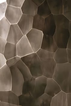 an abstract wall with many different shapes and sizes, including hexagonal tiles on it