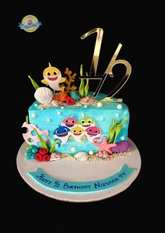 a blue birthday cake with gold numbers and sea animals on it's top is sitting on a plate