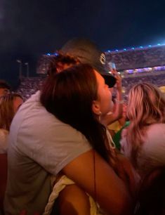 two people hugging each other in front of an audience at a sporting event or concert