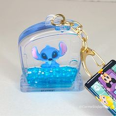 a keychain with an image of a little blue elephant in it and a cell phone attached to it