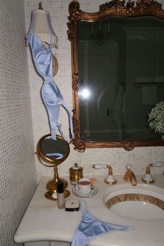 a bathroom with a sink, mirror and other items on the counter in front of it