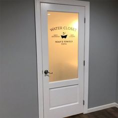 an empty room with a white door and sign that says water closet