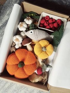 an open box filled with knitted pumpkins and other items