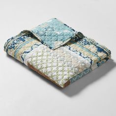 a blue and white quilted comforter on top of a bed