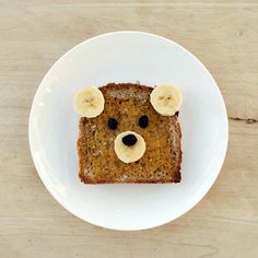 a bear face made out of bread with banana slices on it's ears and eyes