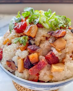 a bowl filled with rice, meat and veggies on top of a table