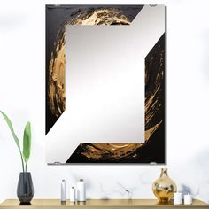 a large mirror hanging on the wall above a table with vases and candle holders