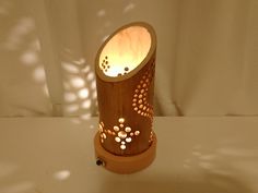 a wooden table lamp sitting on top of a white surface