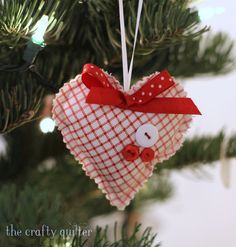 a heart shaped ornament hanging from a christmas tree