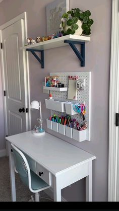 a white desk topped with lots of crafting supplies next to a closet filled with magnets and pens