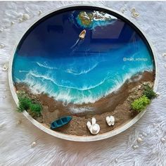 there is a plate that has been made to look like an ocean scene with boats on the beach