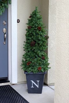 a potted christmas tree with the letter n on it and text overlay that reads quick & easy evergreen topiaryes out of a tomato cage