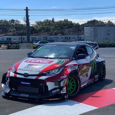 a red and white car parked on top of a race track