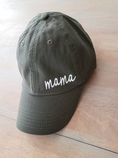 Ok we are obsessed with this mama Hat! How can you go wrong this baby?! For every mama who is too busy to tame their mane and running out of the house slap this adorable hat on! 100% bio-washed chino twill Unstructured, six-panel, low-profile Pre-curved visor Self-fabric tri-glide buckle closure Colors Available Black Olive green FOLLOW US ON SOCIAL MEDIA: Instagram: @righthereathome Facebook: @righthereathome Connect with usWE LOVE TO DO GIVEAWAYS, SHOW SNEAK PEAKS, AND FEATURE ANY SALES WE HAV Olive Hat, Mama Hat, Mom Apparel, Cricut Inspiration, Mom Hat, Mom Hats, Base Ball, Small Boutique, Hat Ideas