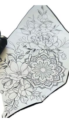 an ink pen is sitting on top of a flowered table cloth that has been drawn