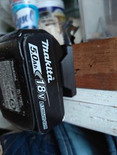 a close up of a metal object on a wooden surface with other items in the background