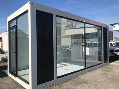 a large white building sitting in the middle of a parking lot with lots of windows