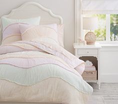 a bed with pink and white comforters in a bedroom