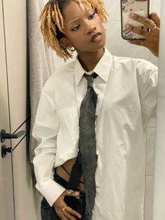 a woman with dreadlocks standing in front of a mirror