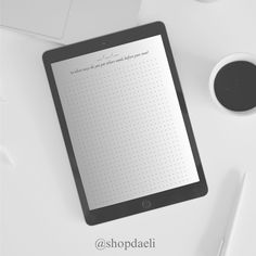 a tablet computer sitting on top of a white desk next to a cup of coffee