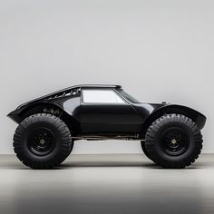 a black monster truck is parked in a room