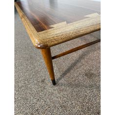 a wooden table sitting on top of a carpeted floor