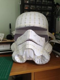 a paper storm trooper helmet sitting on top of a wooden table