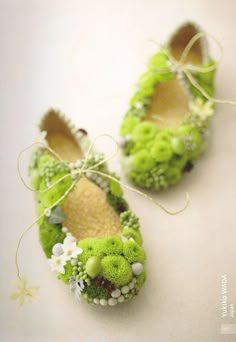 two green shoes with flowers on them sitting next to each other