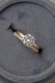 an engagement ring sits on top of a cushion