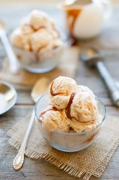 a bowl filled with ice cream sitting on top of a table next to spoons