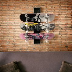 a wall mounted skateboard rack on the side of a brick wall next to a couch