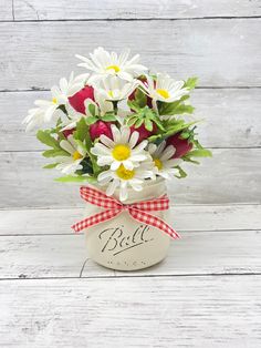 a vase filled with white and red flowers