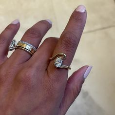 a woman's hand with two different rings on her fingers and one has a diamond in the middle