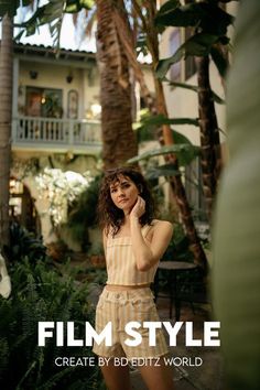 a woman standing in front of a palm tree talking on a cell phone with the words film style below her