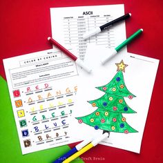 christmas tree color by code activity with crayons and pencils on red background