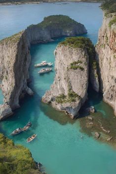 several boats are in the water near some cliffs