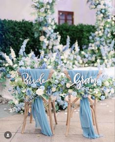 two wooden chairs with blue sashes are decorated with flowers and the word bride and groom written on them