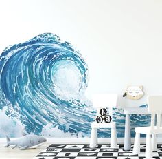 a white chair sitting in front of a wall with a large wave painted on it