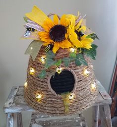 a birdhouse with sunflowers and lights on it