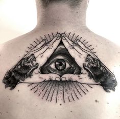 a man's back with two hands holding an all seeing eye tattoo on his chest