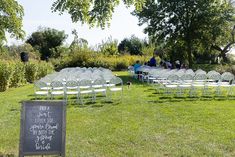 rows of white chairs set up in the middle of a field for an outdoor ceremony