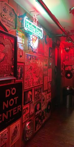 the inside of a bar with neon signs on the walls and posters on the wall