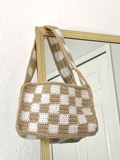 a crocheted purse hanging from a mirror