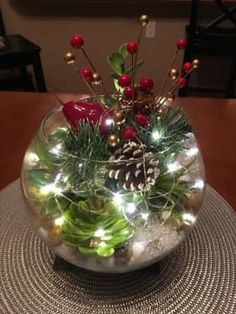 a bowl filled with plants and lights on top of a table