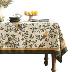 a table topped with lemons next to a vase filled with flowers