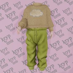 the doll is wearing green pants and a sweater