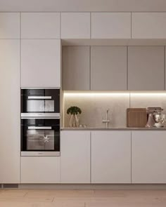 a kitchen with white cabinets and an oven in the center is lit by recessed lighting